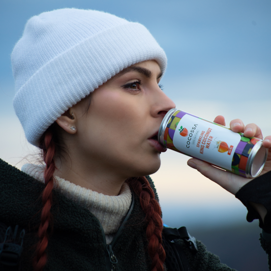 Girl drinking Cocossa Sparkling 100% Natural King Coconut Water from a 250 ml Can.